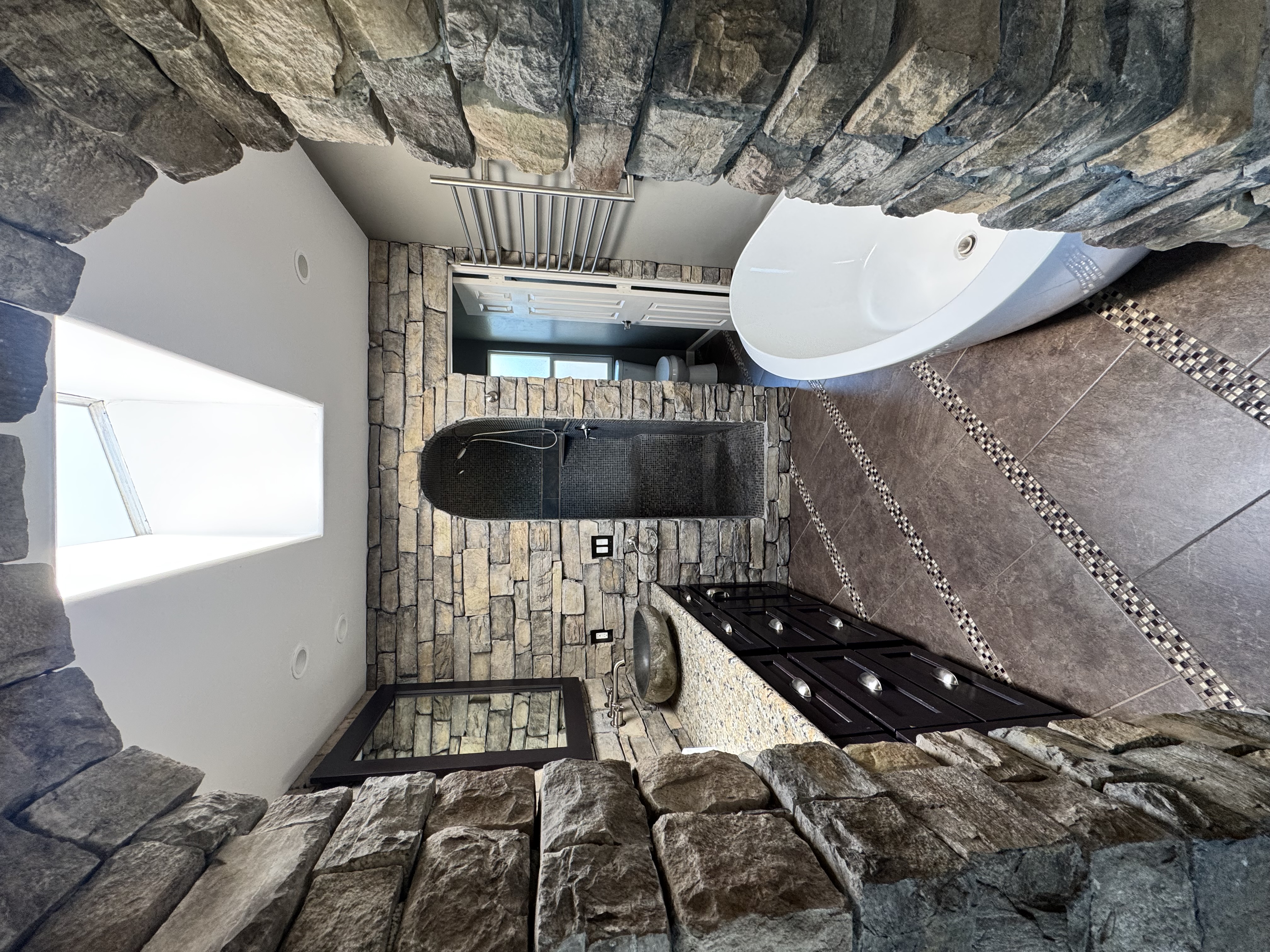 Stone spa bathroom with natural rock walls