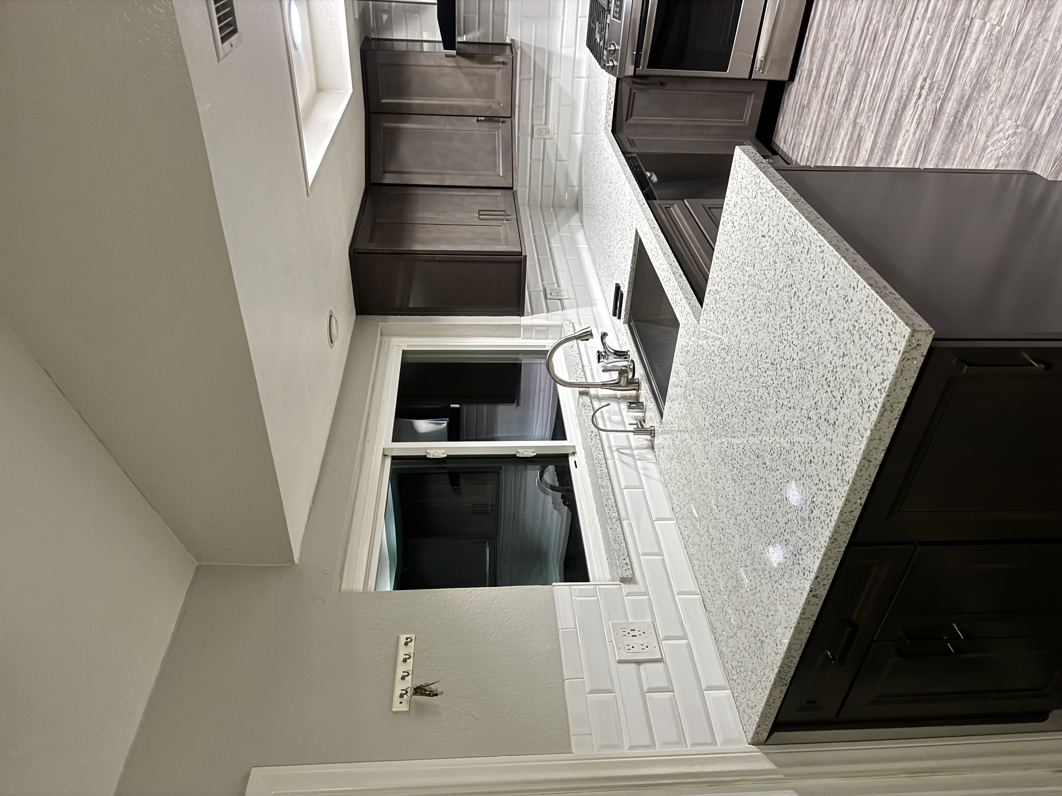 Kitchen counter with granite and subway tile backsplash