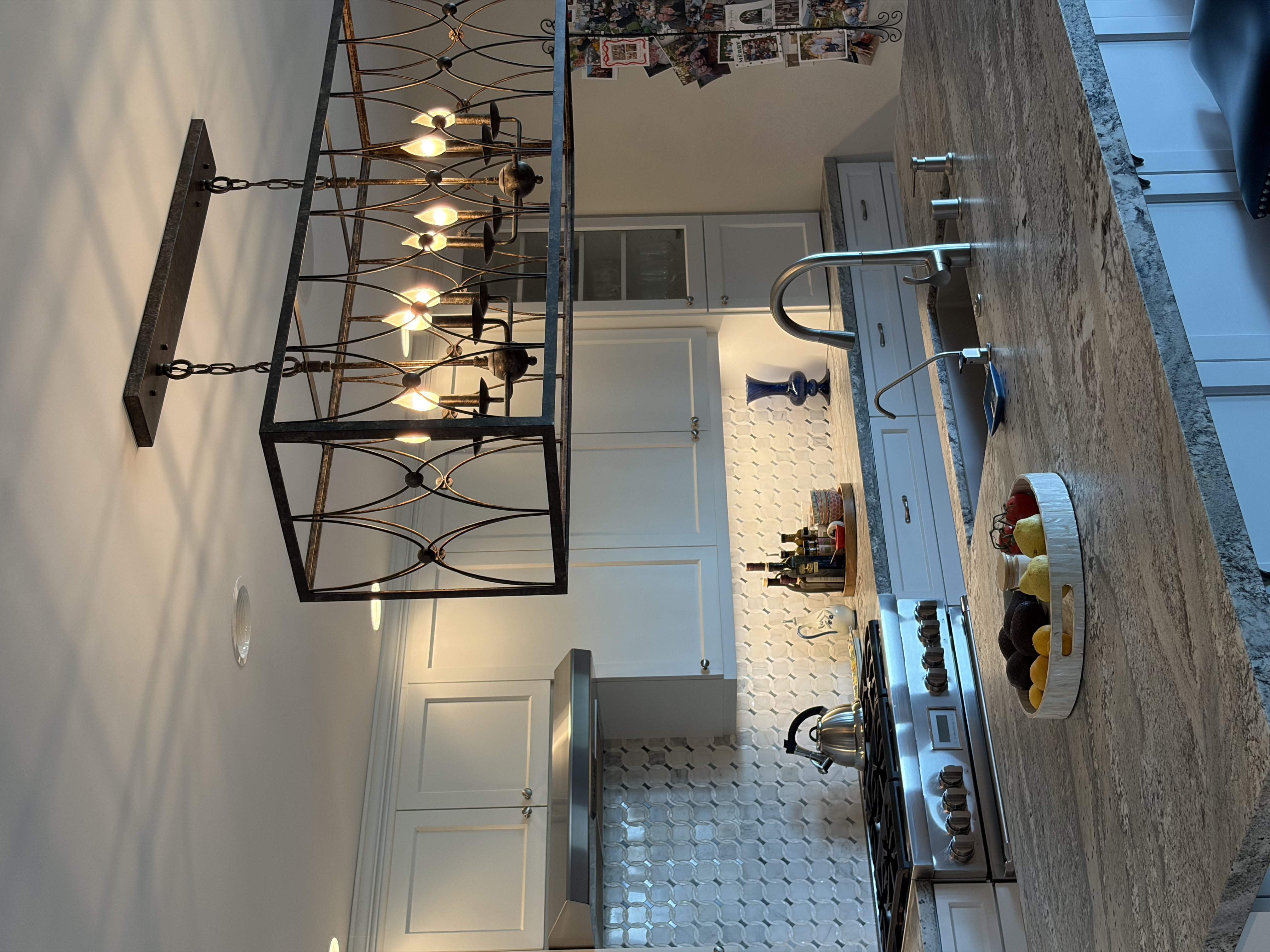 White shaker kitchen with marble island and iron chandelier
