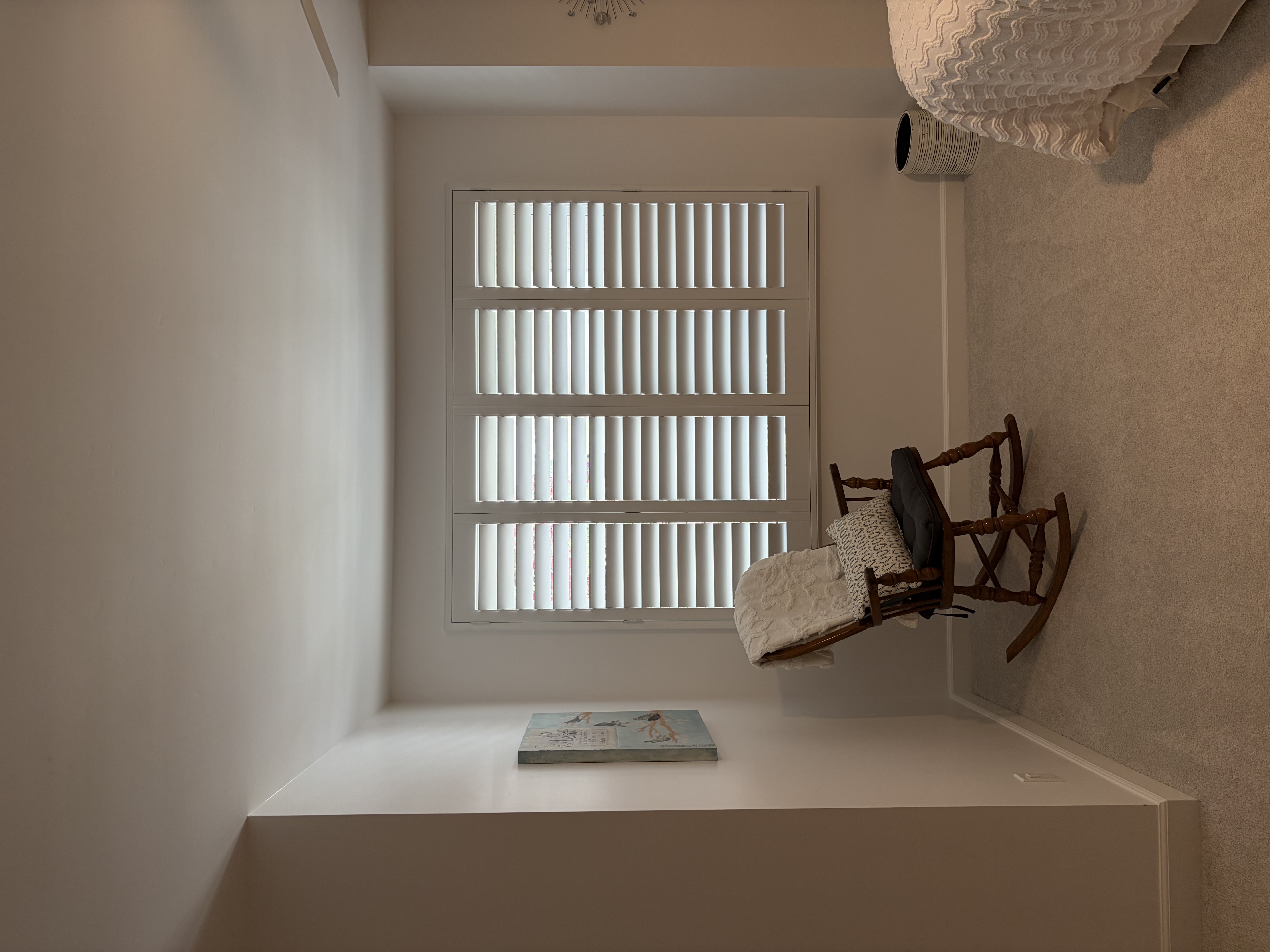Cozy bedroom sitting area with shuttered window
