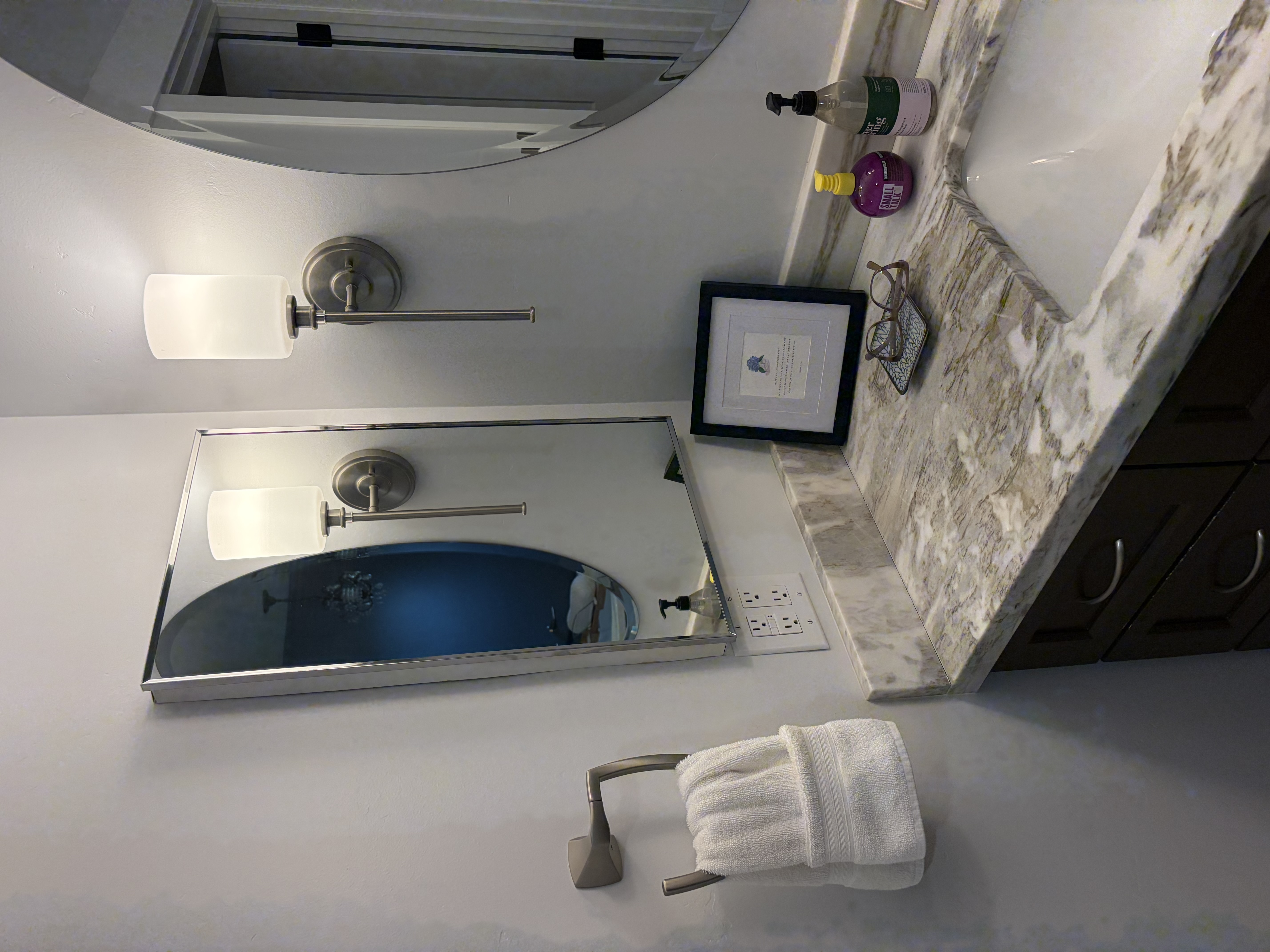 Bathroom vanity counter with folded towel and stone backsplash