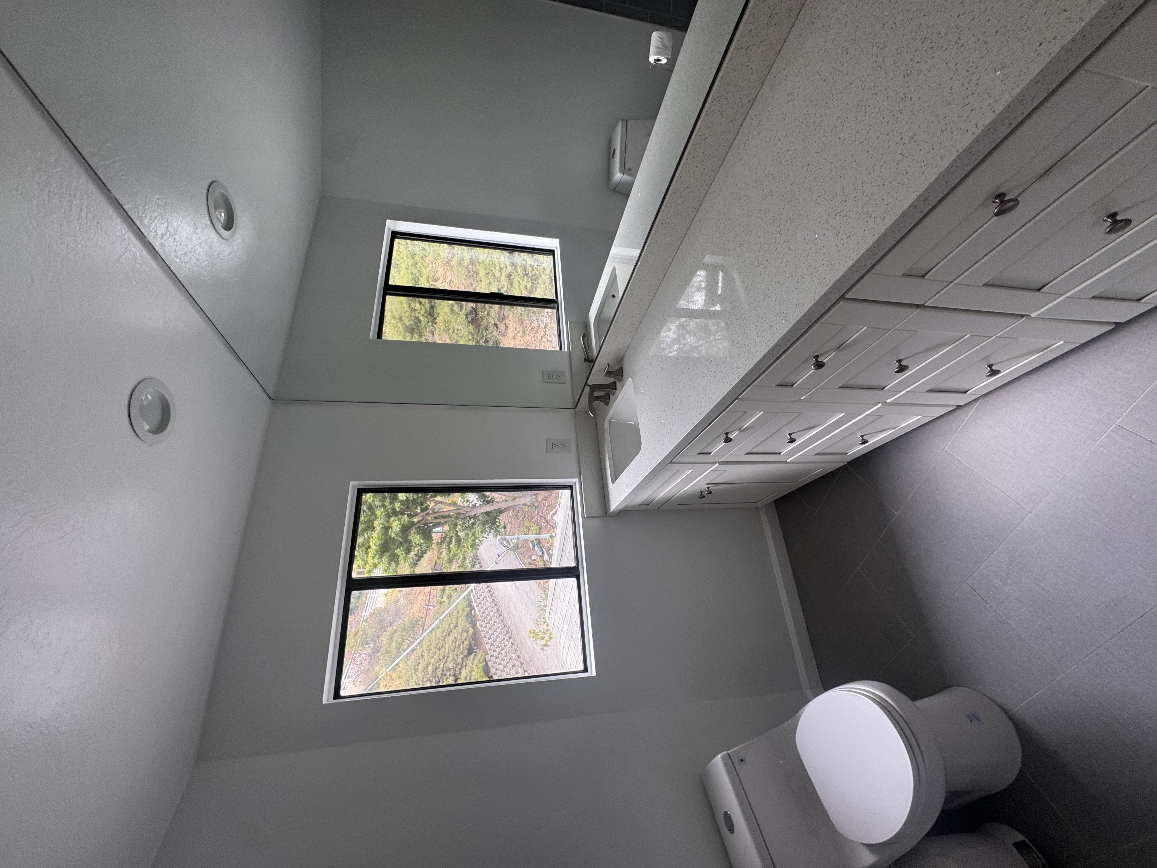 Full bathroom with gray tile and windows