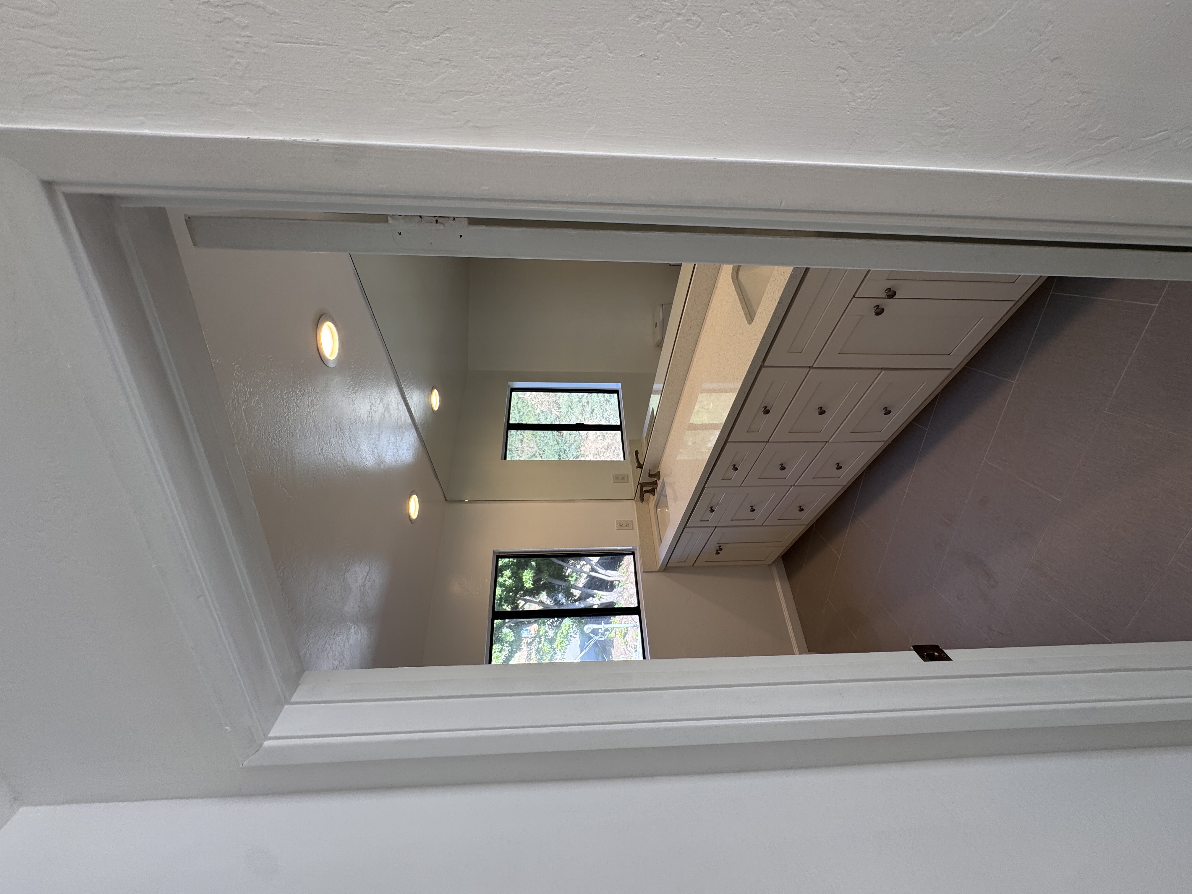 Mirror reflecting a bright luxury bathroom below