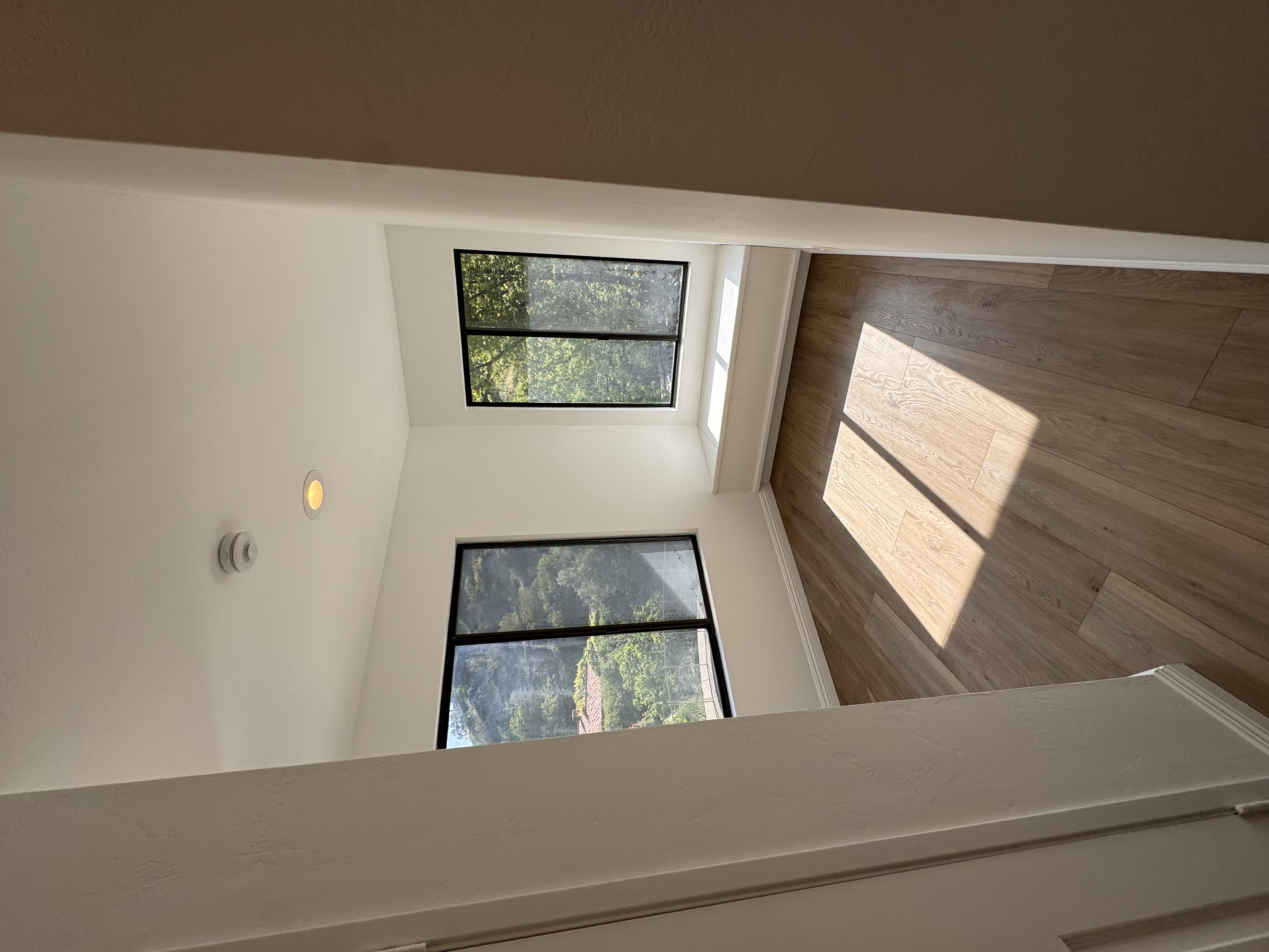Open staircase and hallway with large windows